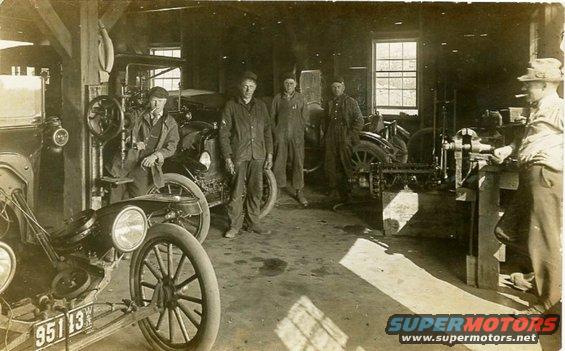 1915 Ford Model T in a garage with men and machinery