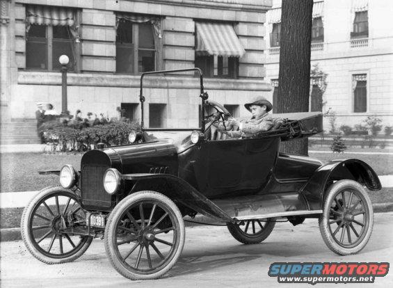 1915 Ford Model T touring car with boy driver. Black exterior, spoked wheels