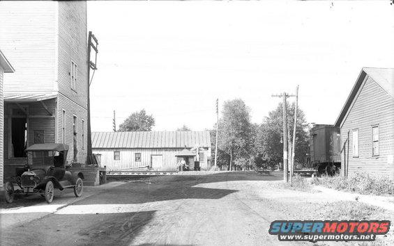 Black 1915 Ford Model T parked next to a building, viewed from the front-left