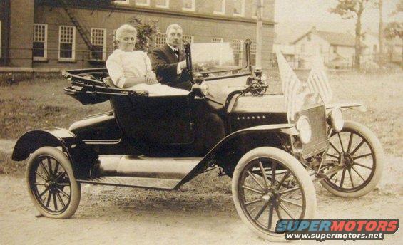 1915 Ford Model T touring car with two passengers and American flags