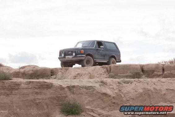 Dark Ford Bronco parked on a dirt mound