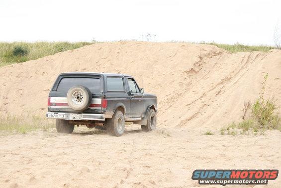 1987 Ford Bronco rear view driving on sand