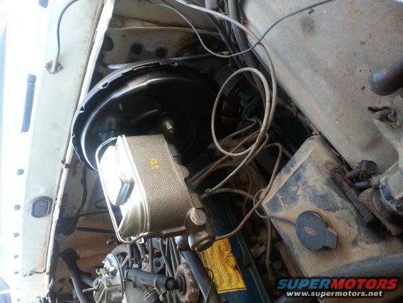 Close-up of brake master cylinder and booster assembly in a vehicle's engine bay