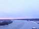 1979 Ford Bronco - Frozen river landscape at dusk with snow on the banks and a faint pink horizon.