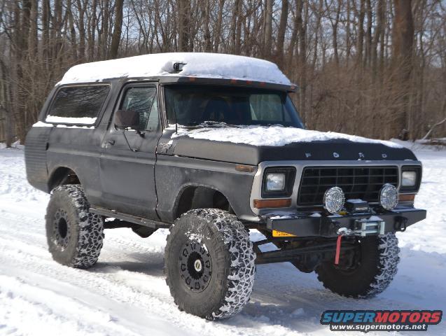 Ford Bronco with big tires in the snow. Has a winch on the front bumper