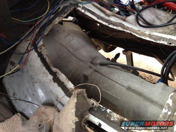 Underneath the carpet, showing the transmission tunnel and lots of wiring