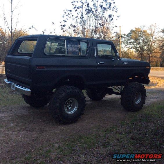 Black lifted 1978 Ford Bronco with large off-road tires, side view