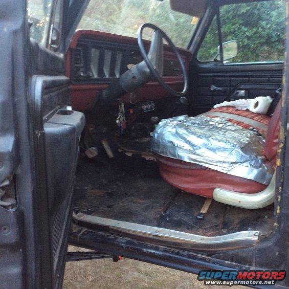 1979 Ford Bronco interior showing dashboard, steering wheel, and covered passenger seat