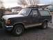 1991 Ford Bronco - A Ford Bronco with a roof rack and brush guard is parked on a gravel driveway.
