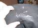 1979 Ford Bronco II - A hand holds a damaged black tire cover with visible white scratches and a tear.