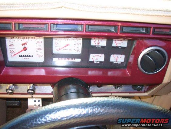 Dashboard with speedometer, tachometer labeled BRONCO, fuel, oil, temp, and charge gauges. Air vent on right