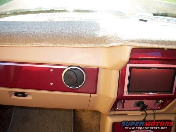 Car interior dashboard with tan and red accents, a circular air vent, and a Pioneer screen. A watermark reads "SUPERMOTORS"