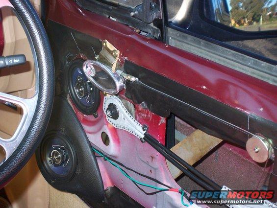 Interior of a car door with speakers and window regulator mechanism visible