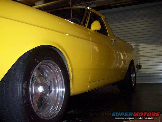 Yellow pickup truck side view, custom wheels, in garage