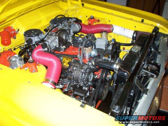 Yellow engine bay with red intake hoses and a black radiator