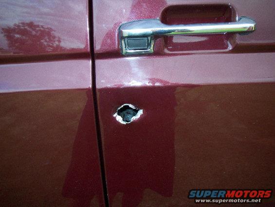 1985 Ford Bronco door with a hole punched through it near the handle