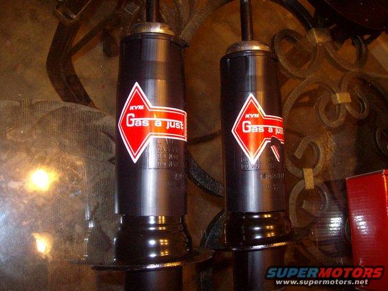 Two KYB Gas-a-just shock absorbers with red and white diamond logos