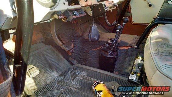 Interior view of vehicle with dual stick shifters and floor mats