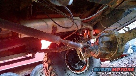 Undercarriage view showing leaf springs, driveshaft, and rear differential housing. A Supermotors.net logo is visible