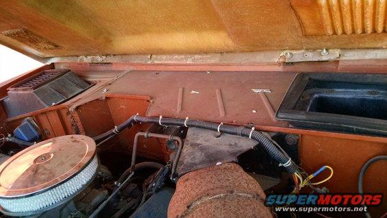 Engine bay with orange interior panels and a round air filter