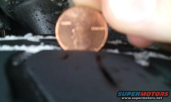 Penny placed in tire tread groove, showing tread depth