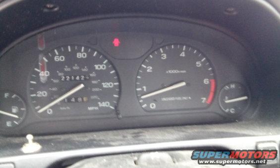Car dashboard with speedometer showing 221425 miles and tachometer