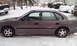 1996 Subaru Legacy - A brown sedan sits parked in the snow, partially obscured by winter weather.