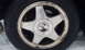 1996 Subaru Legacy - A close-up of a dirty Subaru wheel, showing the tire and the center cap with the brand logo.