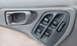 1996 Subaru Legacy - Close-up of a car's interior door panel showing the window controls and door handle.