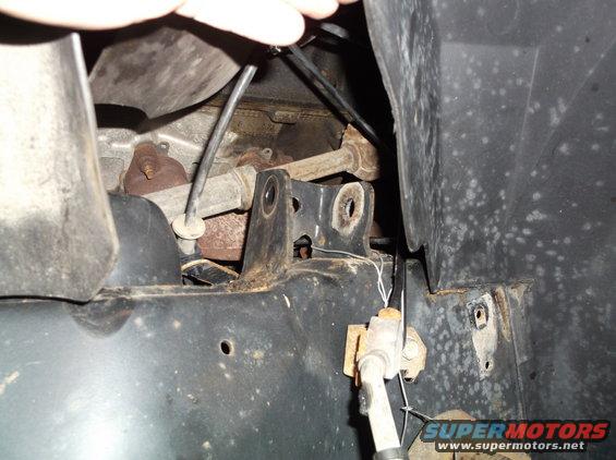 close-up of rusty frame, suspension parts, and wiring under a vehicle