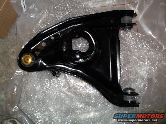 Black control arm with gold bushing, wrapped in bubble wrap