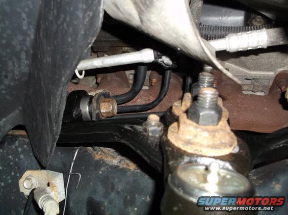 Close-up of rusty ball joint and suspension linkage under a vehicle