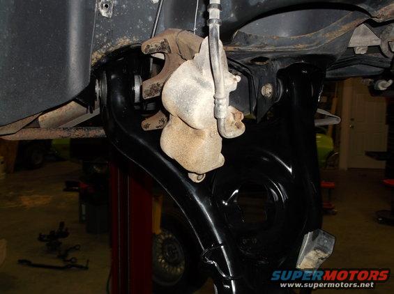 close-up of car's front brake caliper and suspension components