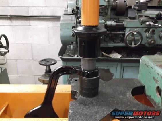 Black metal part with orange cap on machinery