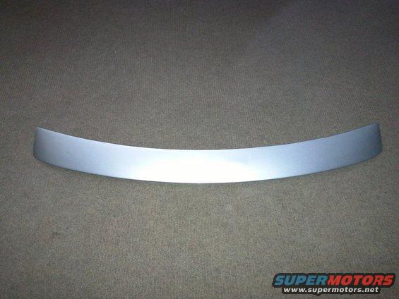 Curved silver trim piece on a textured gray background
