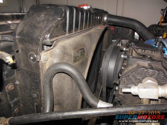 Radiator and fan shroud assembly with hoses and belts visible