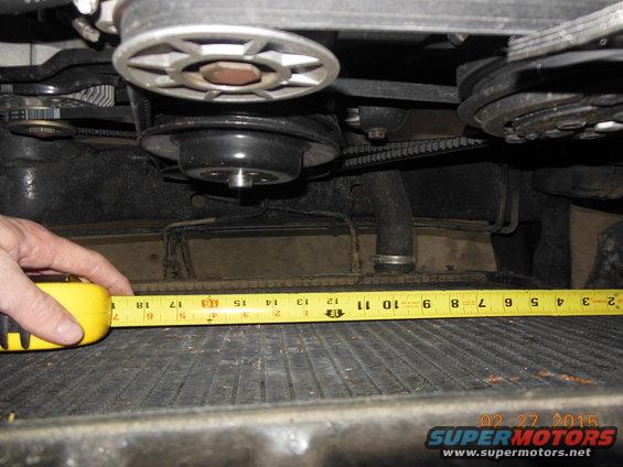 Close-up of engine bay with a yellow tape measure across a radiator