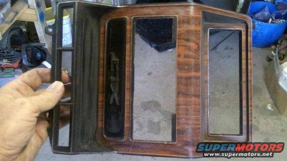 Wood-grain trim piece with 'GTX' emblem and openings for gauges
