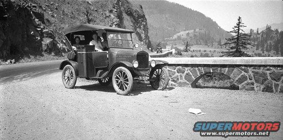 1920s Ford Model T touring car on a dirt road with passengers