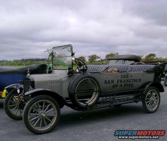 Gray 1915 Ford Model T Touring Car with "SEE SAN FRANCISCO ON A DIME" text on its side, parked outdoors