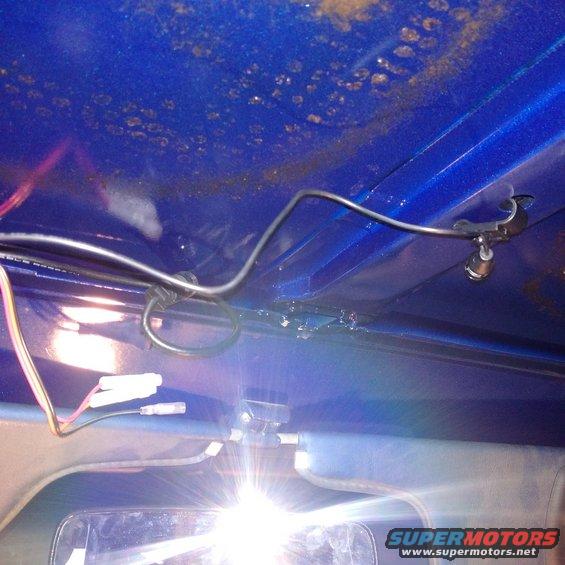 Interior view showing wiring harness and rearview mirror, with blue painted metal overhead