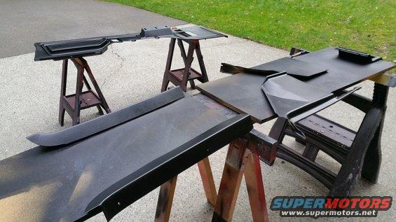 Black interior trim pieces drying on sawhorses, with SuperMotors logo visible