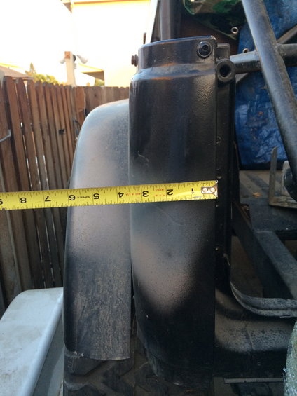Measuring tape on black rear quarter panel and tail light assembly