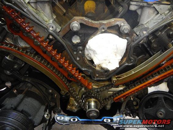 Engine timing chain and guides disassembled. White cloth stuffed into engine cavity