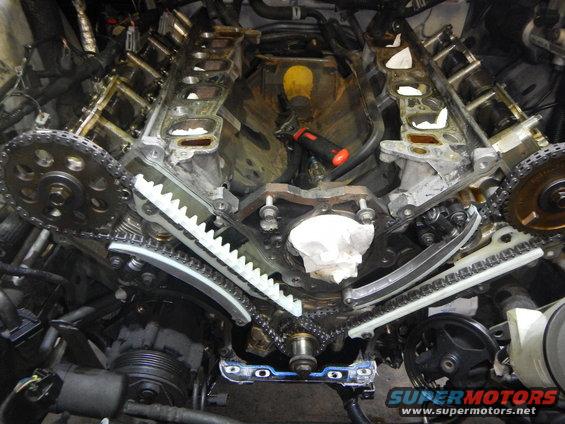 Ford V8 engine timing chain and guides during replacement. Tools are visible