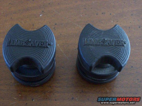 Two black LIMBSAVER parts with textured surfaces and embossed logos sit on a wooden surface