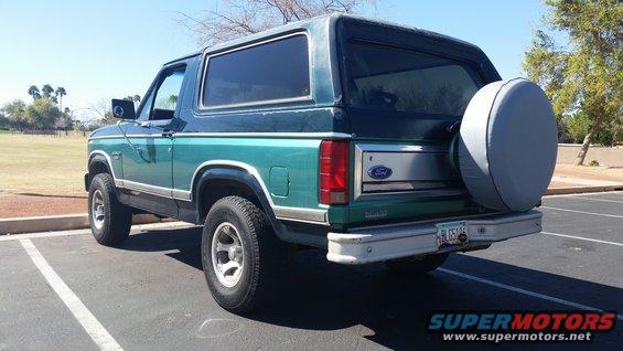 Green Ford Bronco parked outside, spare tire on back