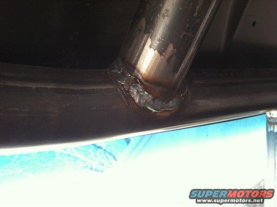 Close-up of a welded exhaust pipe connection underneath a vehicle