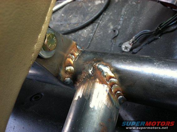Welded metal frame with bolt and wiring inside vehicle interior