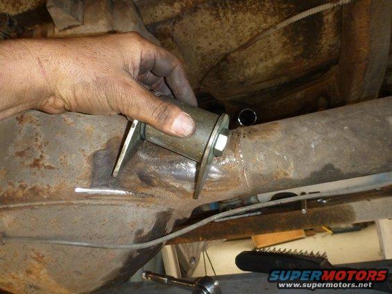 Hand installing a suspension bushing onto a metal axle housing